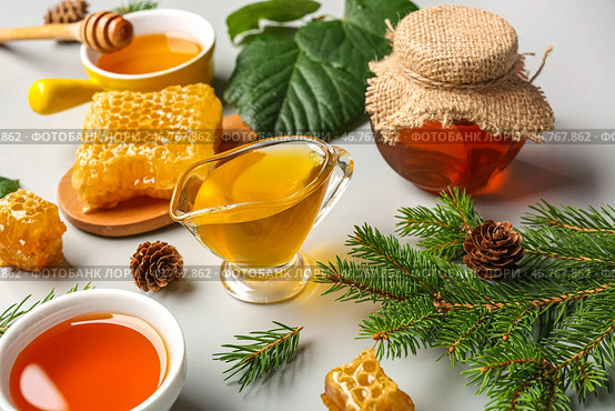 Банка с вкусным медом, медовым сотом и ветками пихты на белом фоне, крупным планом. Стоковое фото, фотограф Pixel_shot / Фотобанк Лори