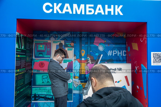 Банкомат и информационный стенд о предотвращении мошенничества с банковскими картами на площадке киберфестиваля Positive Hack Days в Парке Горького города Москвы, Россия (2023 год). Редакционное фото, фотограф Николай Винокуров / Фотобанк Лори