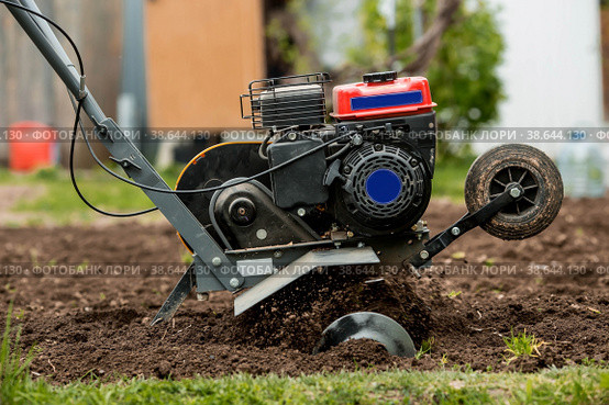 Banner. A male farmer plows the land with a cultivator. Agricultural machinery for tillage in the garden, combine harvester. Стоковое фото, фотограф Photojuli / Фотобанк Лори