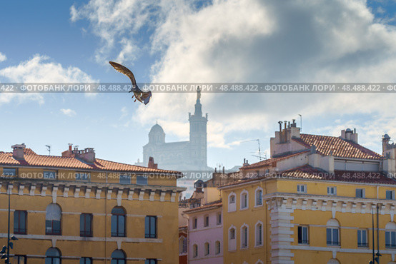 Basilique Notre-Dame de la Garde in the foggy background with red tiled roof Marseille houses (2018 год). Стоковое фото, фотограф Сергей Богомяко / Фотобанк Лори