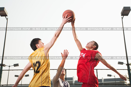 Basketball players fighting for a ball . Стоковое фото, агентство Ingram Publishing / Фотобанк Лори