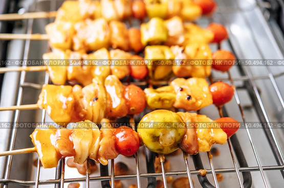BBQ grill with a variety of meats, complete with tomatoes and bell peppers. Стоковое фото, агентство Ingram Publishing / Фотобанк Лори