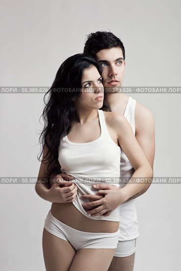 Beautiful and attractive young couple in underwear standing over a white background. Стоковое фото, агентство Ingram Publishing / Фотобанк Лори