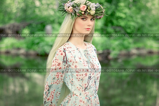 Beautiful blonde woman with flower wreath on her head. Beauty girl with flowers hairstyle. Girl in a summer forest. Fashion photo. Стоковое фото, агентство Ingram Publishing / Фотобанк Лори