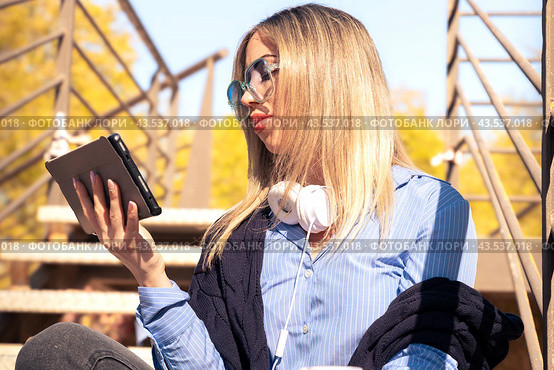 Beautiful caucasian woman with surfing the internet on digital tablet outdoors. Стоковое фото, фотограф Raquel Corcoles Mendez / Фотобанк Лори