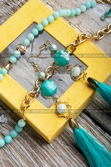 beautiful handmade  turquoise  jewelry with natural gems in yellow box around old style wooden background. macro shot. fashion concept. Стоковое фото, агентство Ingram Publishing / Фотобанк Лори