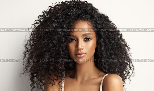 Beautiful laughing brunette model african woman with long curly hair . Smiling gir afro hairstyle wavy curls . Fashion , beauty and makeup portrait . Dark skin , Beauty cosmetology portrait. Стоковое фото, фотограф Sofia Zhuravetc / Фотобанк Лори
