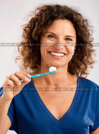 Beautiful mature woman brushing her teeths . Стоковое фото, агентство Ingram Publishing / Фотобанк Лори