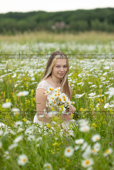 Beautiful romantic teen girl, young woman with a bouquet of wildflowers in the field on a sunny summer day. Child with disabilities. Equal opportunities for all. Стоковое фото, фотограф Ирина Михайличенко / Фотобанк Лори
