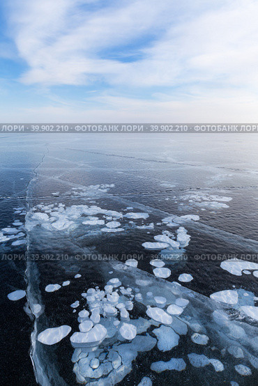 Beautiful winter landscape of frozen Baikal Lake in cold February day. Endless ice fields with white cracks and bubbles. Natural seasonal background. Winter ice travel and active outdoors. Стоковое фото, фотограф Виктория Катьянова / Фотобанк Лори