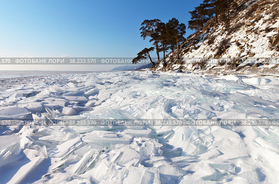 Beautiful winter landscape of frozen Lake Baikal on a sunny day. The lake shore is covered with ice hummocks of transparent snowy ice floes. Winter holidays and ice travel. Natural background. Стоковое фото, фотограф Виктория Катьянова / Фотобанк Лори