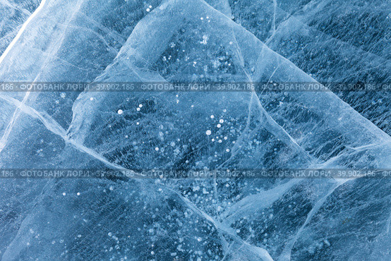 Beautiful winter natural ice texture of frozen Baikal Lake in cold February day. Blue ice surface with pattern of white cracks and bubbles. Natural background, mock up, copy space, flat lay, blank, close-up. Стоковое фото, фотограф Виктория Катьянова / Фотобанк Лори
