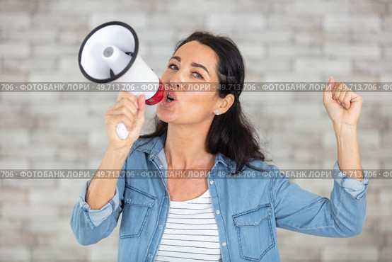 beautiful woman excited and euphoric shouting with a megaphone. Стоковое фото, агентство Ingram Publishing / Фотобанк Лори