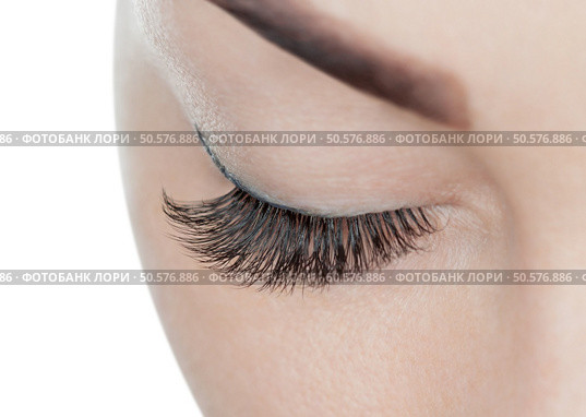 Beautiful Woman with long eyelashes in a beauty salon. Eyelash extension procedure. Lashes close up. Стоковое фото, агентство Ingram Publishing / Фотобанк Лори