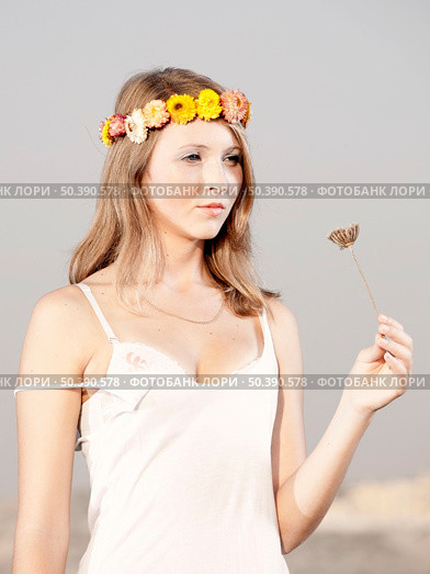 Beautiful young woman in a meadow wearing a crown of flowers. Стоковое фото, агентство Ingram Publishing / Фотобанк Лори