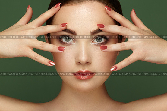 Beauty brunette woman with perfect makeup. Glamour girl. Red lips and nails. Perfect eyebrows. Skin care foundation. Beauty girls face isolated on green background. Fashion photo. Стоковое фото, агентство Ingram Publishing / Фотобанк Лори