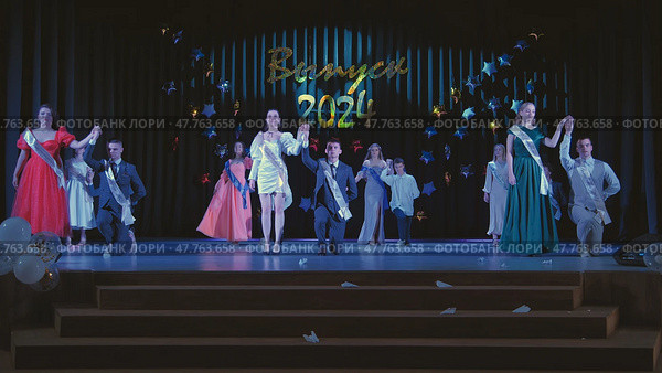 Berdovka, Belarus - June 17, 2024: Elegant students celebrating their graduation ceremony on a stage, wearing sashes and formal attire. Редакционное фото, фотограф Mikhail Davidovich / Фотобанк Лори