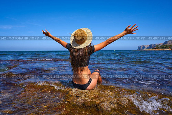 Bikini girl in summer Mediterranean beach having fun sit open arms excited. Стоковое фото, агентство Ingram Publishing / Фотобанк Лори