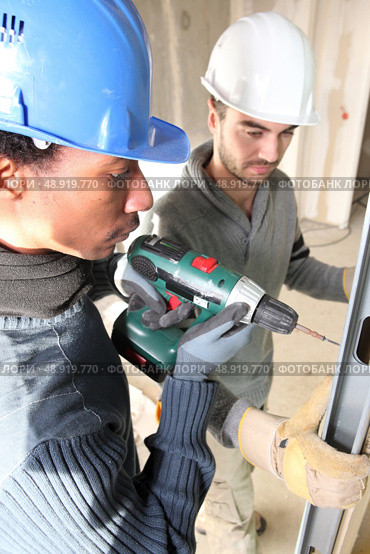 black and white carpenters at work with electric drill. Стоковое фото, агентство Ingram Publishing / Фотобанк Лори