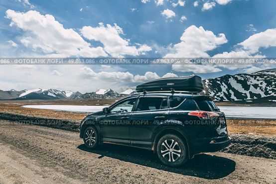 Black car on the side of a gravel road in a natural location. Toyota RAV-4 with roof rack. Road trip. Arabel plateau, Barskoon gorge. Редакционное фото, фотограф Екатерина Якименко / Фотобанк Лори