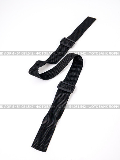 Black strap lies in a zigzag pattern on a white background. Стоковое фото, фотограф Катерина Белякина / Фотобанк Лори