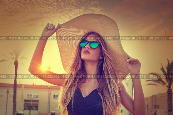 Blond teen girl sunglasses and pamela sun hat at palm tree sunset filtered image. Стоковое фото, агентство Ingram Publishing / Фотобанк Лори
