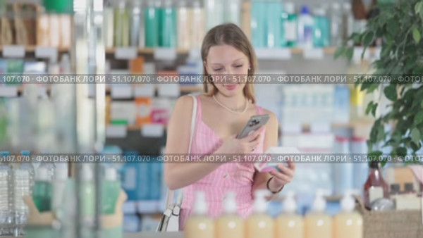 Blonde shopper scans mobile barcode of pill packs in pharmacy. Стоковое видео, видеограф Яков Филимонов / Фотобанк Лори