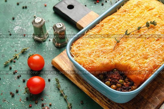 Блюдо для выпечки с вкусным пастушьим пирогом на зеленом фоне, крупным планом. Стоковое фото, фотограф Pixel_shot / Фотобанк Лори