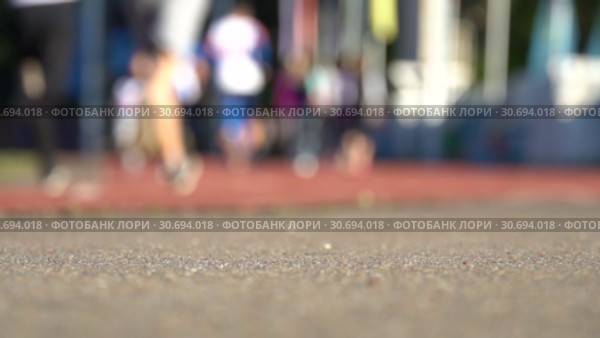 Blurred background of runners on stadium. Amateur sport footage slowmotion. Стоковое видео, видеограф Dmitry Domashenko / Фотобанк Лори