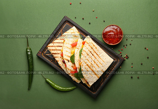 Board with tasty vegetarian quesadillas, chili peppers and sauce on color background. Стоковое фото, фотограф Pixel_shot / Фотобанк Лори
