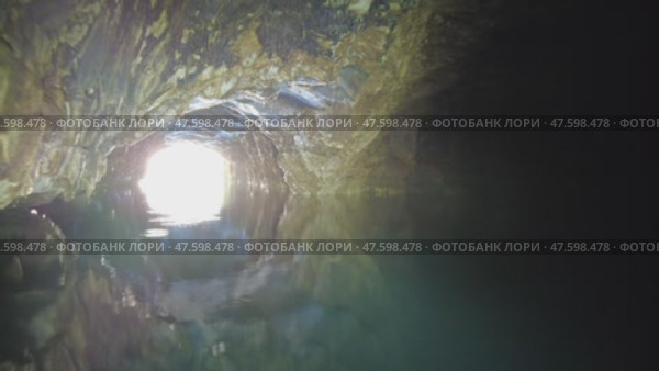 Boating on underground river in dark cave. Стоковое видео, видеограф Михаил Коханчиков / Фотобанк Лори