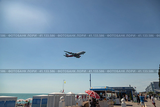 Boeing 747 of Rossiya Airlines lands at Adler Airport from the sea, above the beach with tourists (2022 год). Редакционное фото, фотограф Сергей Сергеев / Фотобанк Лори