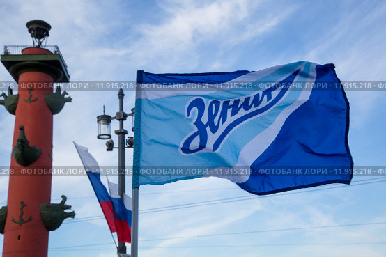 Болельщик держит флаг с символикой футбольного клуба "Зенит" в городе Санкт-Петербурге (2015 год). Редакционное фото, фотограф Николай Винокуров / Фотобанк Лори