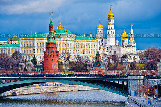 Большой Кремлевский дворец, башни и церкви московского Кремля. Зимний день. Черные тучи и солнечный свет. Москва. Россия. Редакционное фото, фотограф E. O. / Фотобанк Лори