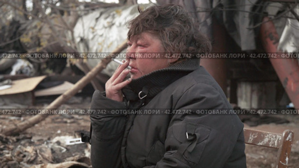 Бомж, бездомная женщина бродяга. Homeless woman vagabond in a temporary place smoking a cigarette. Стоковое видео, видеограф EStarodubov / Фотобанк Лори