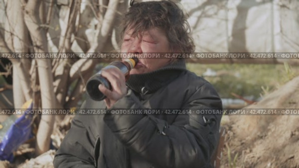 Бомж, бездомная женщина бродяга. Portrait homeless woman vagabond in a temporary place is drinking beer. Стоковое видео, видеограф EStarodubov / Фотобанк Лори