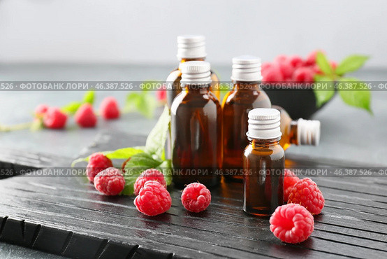 Bottles of raspberry essential oil on table. Стоковое фото, фотограф Pixel_shot / Фотобанк Лори