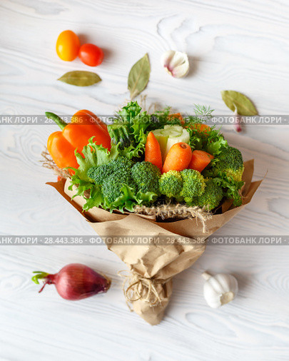 Bouquet of fresh vegetables lies on a white wooden table. Nearby is a red onion, tomatoes, garlic, bay leaf. View from above. Стоковое фото, фотограф Олег Белов / Фотобанк Лори