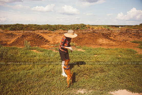 Boy child running, dog and puppy chasing across corn field. Boy loves freedom, child loves sun and sky. Dog running quickly, puppy running near. Field wide, dirt dry, sky endless, freedom alive. Стоковое фото, фотограф Юлия Киселёва / Фотобанк Лори