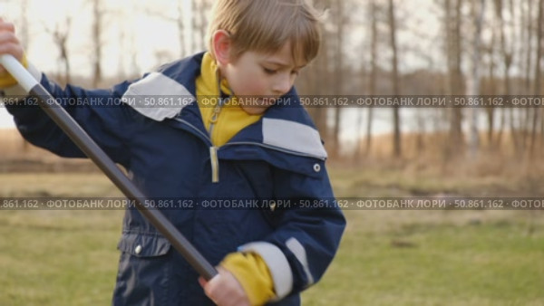 Boy Raking Up Autumn Leaves at the Home Backyard. Fall season. Seasonal garden yard work outside. Busy blonde child helps to mom gardening autumnal lawn. Cute kid learn planting. Young Raker. Chores. Стоковое видео, видеограф Марина Демидюк / Фотобанк Лори