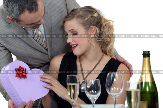Boyfriend surprising girlfriend with heart-shaped box. Стоковое фото, агентство Ingram Publishing / Фотобанк Лори