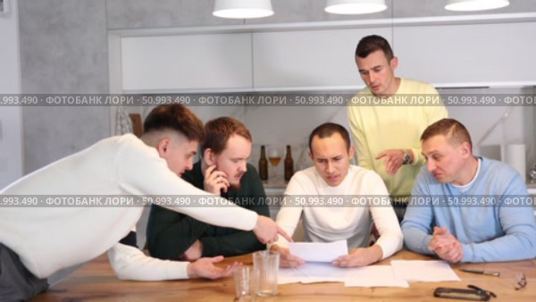 Brainstorming - male friends trying to solve financial problems by consulting at the table in the home kitchen. Стоковое видео, видеограф Яков Филимонов / Фотобанк Лори