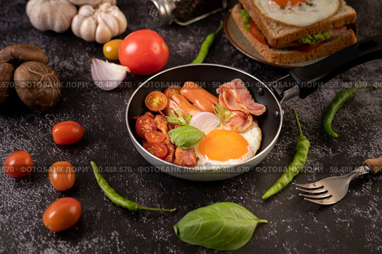 Breakfast with fried eggs, sausage, and ham in a pan with tomatoes. Chili and basil. Стоковое фото, агентство Ingram Publishing / Фотобанк Лори