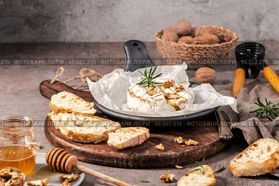 Brie type of cheese. Camembert cheese. Fresh sliced Brie cheese on a wooden tray with nuts, honey and leaves. Italian, French cheese. Стоковое фото, агентство Ingram Publishing / Фотобанк Лори
