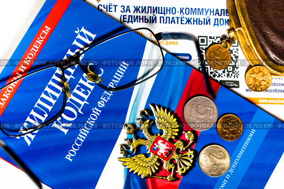 Брошюра с Жилищным кодексом Российской Федерации, платежка за коммунальные услуги и кошелек с мелочью на белом фоне (2023 год). Редакционное фото, фотограф Николай Винокуров / Фотобанк Лори