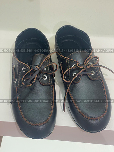 Brown leather lace-up shoes on white shelf. Редакционное фото, фотограф Данил Руденко / Фотобанк Лори
