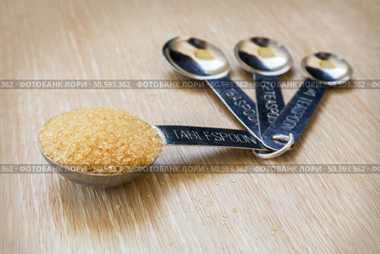 Brown sugar on measuring spoons. Стоковое фото, агентство Ingram Publishing / Фотобанк Лори