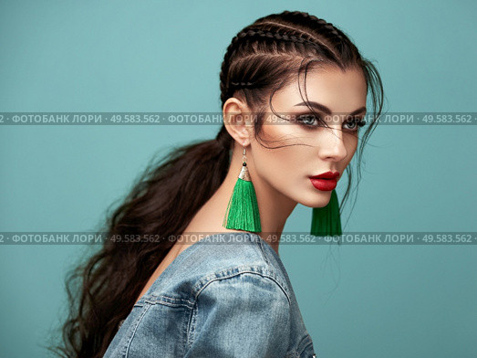 Brunette girl with perfect makeup. Beautiful model woman with curly hairstyle. Care and beauty hair products. Lady with braided hair. Model with jewelry. Turquoise background. Стоковое фото, агентство Ingram Publishing / Фотобанк Лори