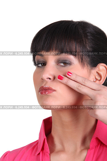 Brunette holding two finger to face. Стоковое фото, фотограф Phovoir Images / Фотобанк Лори