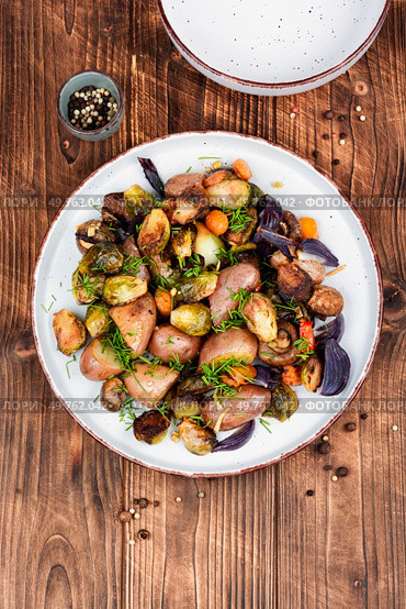 Brussels sprouts and potatoes caramelized on wooden kitchen table. Healthy eating. Rustic Style. Roasted vegetable medley including potatoes brussels sprout. Стоковое фото, агентство Ingram Publishing / Фотобанк Лори